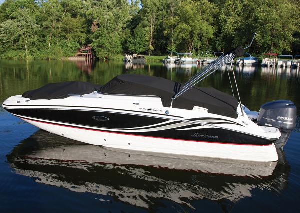 Hurricane SunDeck 2400 OB Manufacturer Provided Image: 2013 Hurricane SunDeck 2400 OB boat on a calm lake with lush green trees.