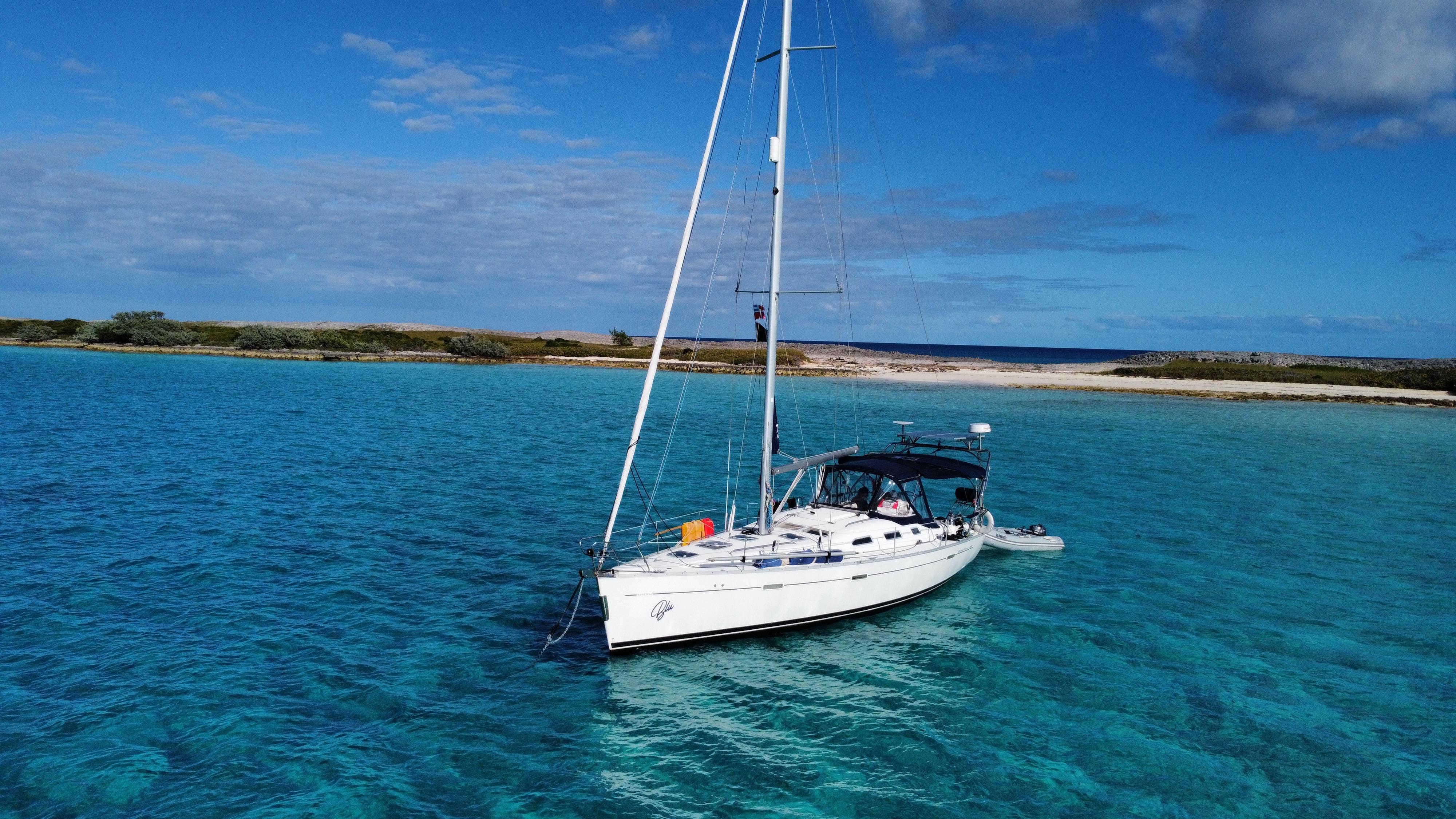 Beneteau 393 Sailboat Beneteau 393 (2002) anchored in clear turquoise waters near a sandy beach.