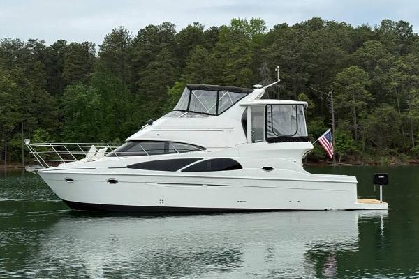 Carver 41 Cockpit Motor Yacht 2005 Carver 41 Cockpit Motor Yacht on a serene lake with forest backdrop.
