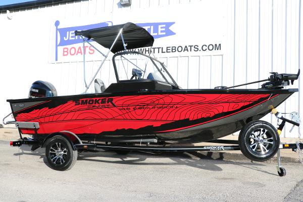 Smoker Craft Excursion 166 DC 2025 Smoker Craft Excursion 166 DC boat with red and black design, parked outside a dealership.