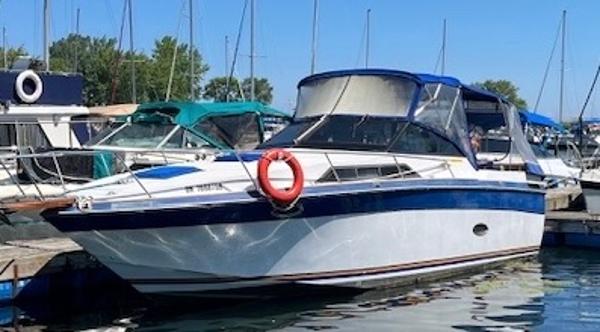 Regal Commodore 277 1987 Regal Commodore 277 boat docked at marina with blue canopy and lifebuoy.