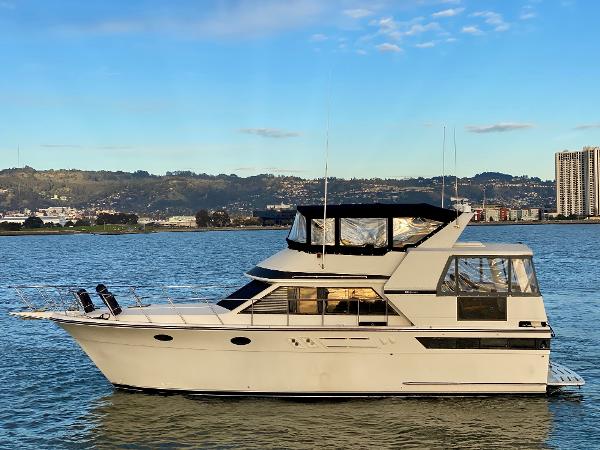 Californian Sundeck Motoryacht 1988 Californian Sundeck Motoryacht on calm water with cityscape background.