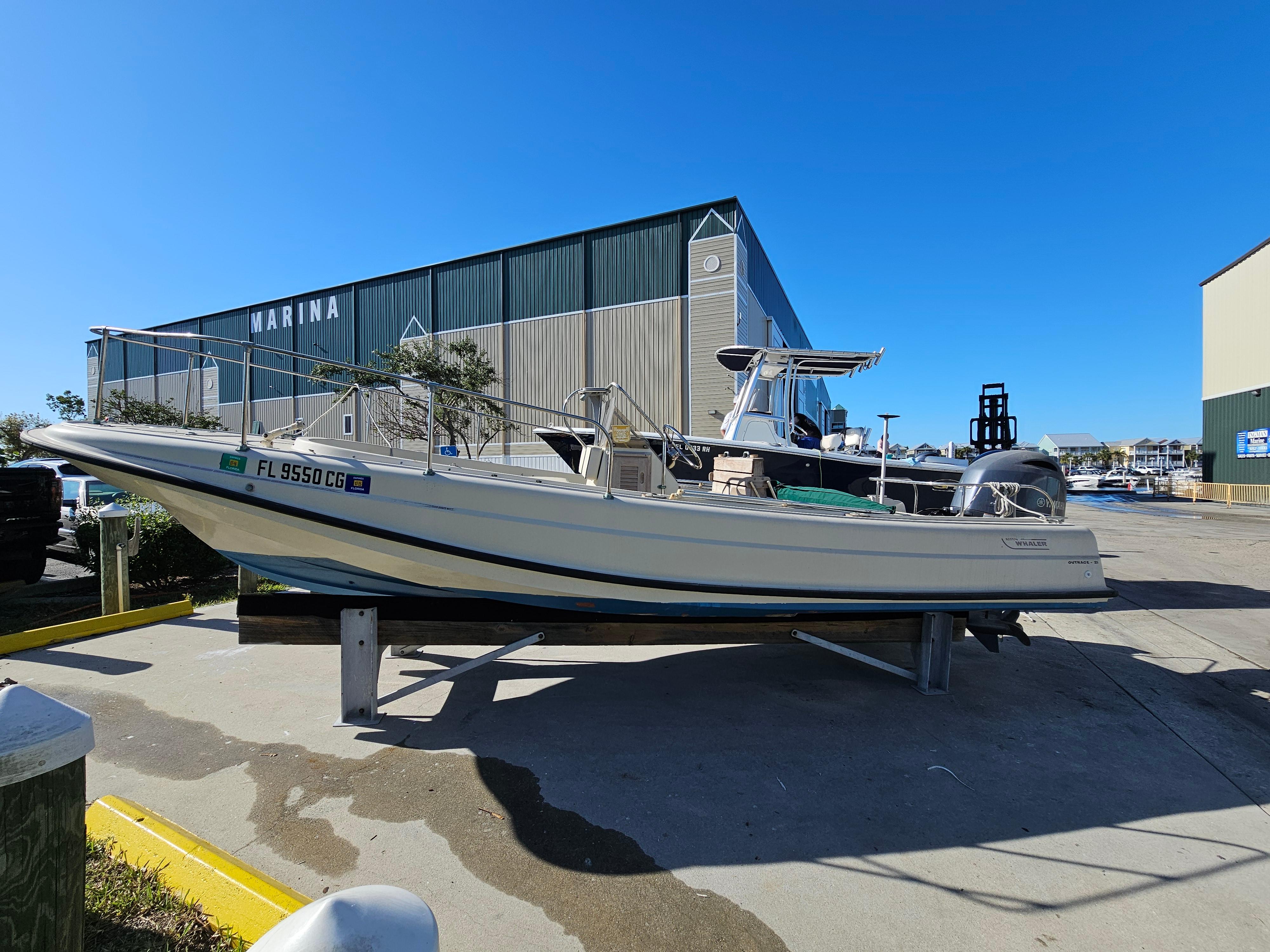 Boston Whaler 21 Outrage 1977 Boston Whaler 21 Outrage boat at marina, clear blue sky background.