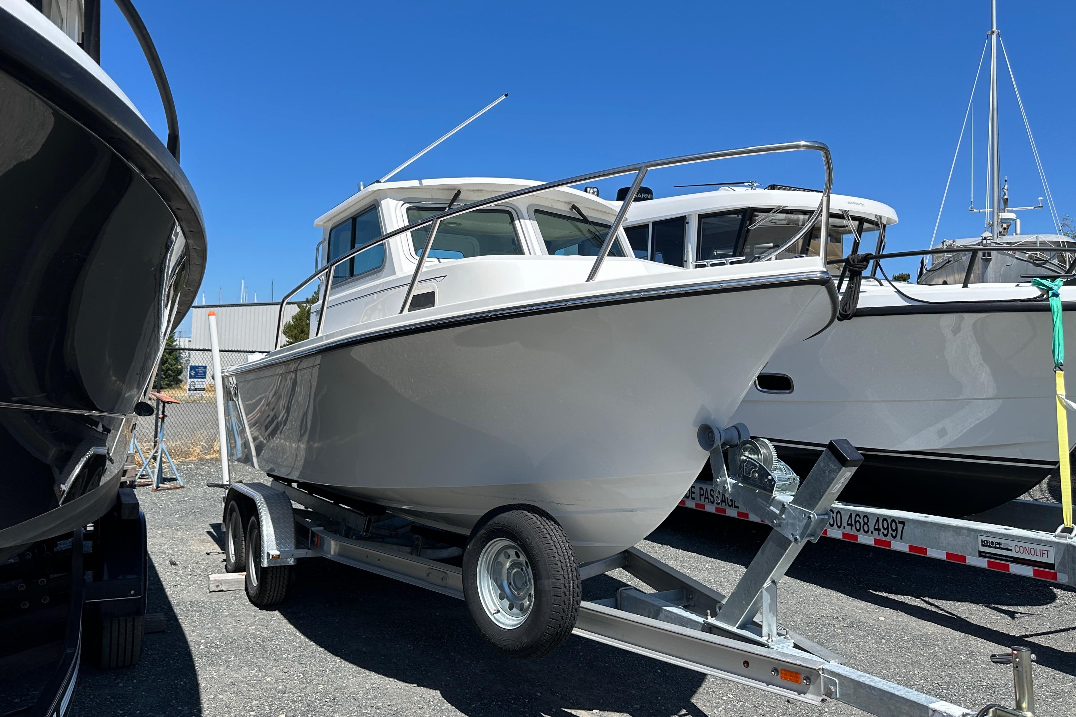 Parker 2120 Sport Cabin 2025 Parker 2120 Sport Cabin boat on trailer, displayed outdoors under clear blue sky.