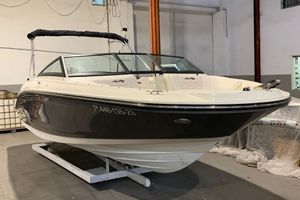Sea Ray SPX 210 Outboard 2023 Sea Ray SPX 210 Outboard boat in a showroom, featuring sleek black and white design.