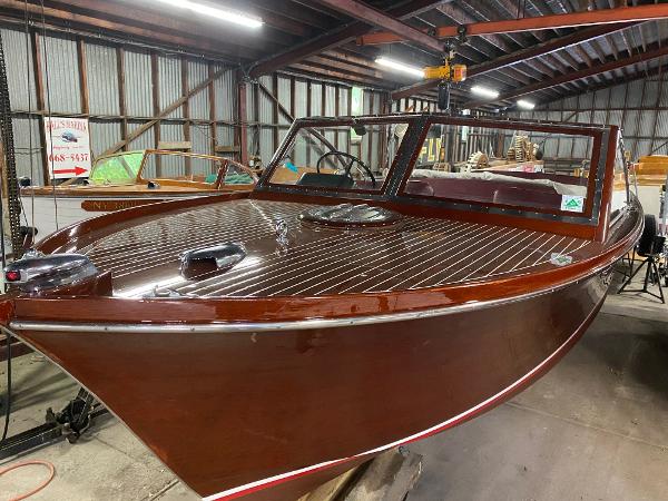 Chris-Craft Sportsman 1959 Chris-Craft Sportsman boat in a warehouse, polished wooden finish.