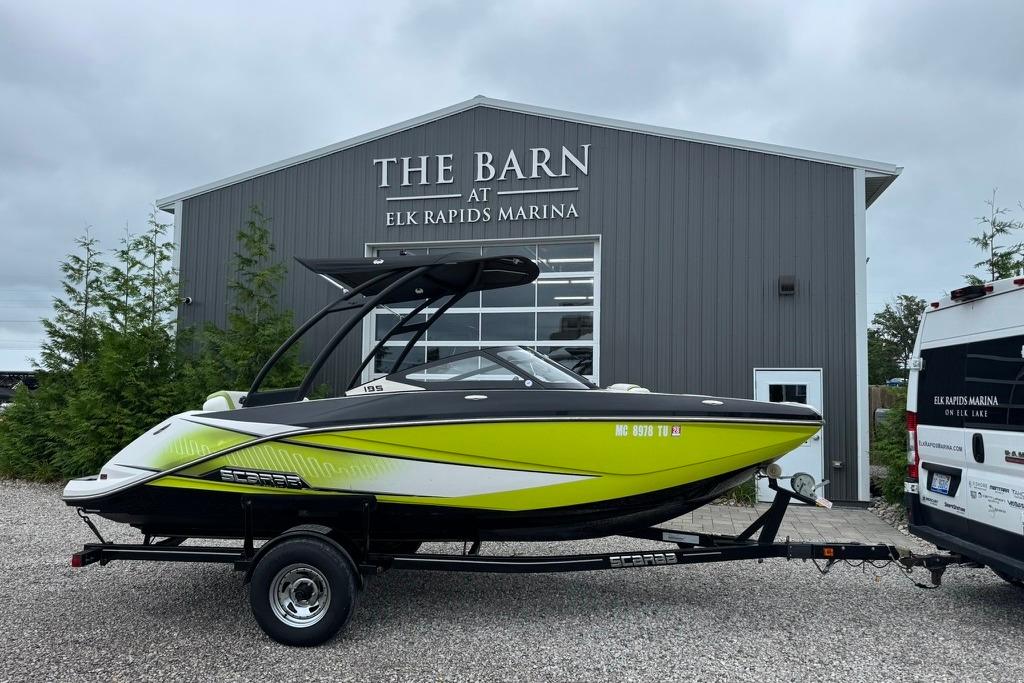 Scarab 195 2015 Scarab 195 boat on trailer at Elk Rapids Marina, in front of The Barn.