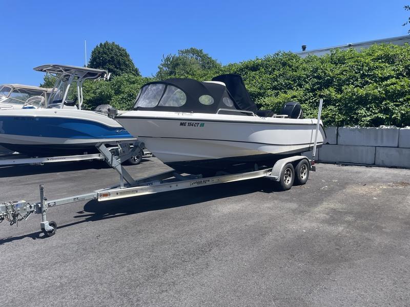 Boston Whaler 210 Outrage 2006 Boston Whaler 210 Outrage boat on trailer, parked outdoors on sunny day.