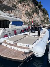 Magazzu 13.30 2011 Magazzu 13.30 boat docked in a scenic marina with rocky cliffs.