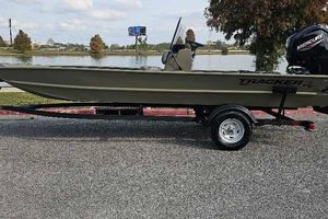 Tracker Grizzly 1860 CC 2026 Tracker Grizzly 1860 CC boat on trailer by a lake.