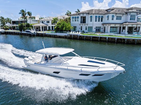 Intrepid 41 Valor 2024 Intrepid 41 Valor cruising on a canal near luxury waterfront homes.