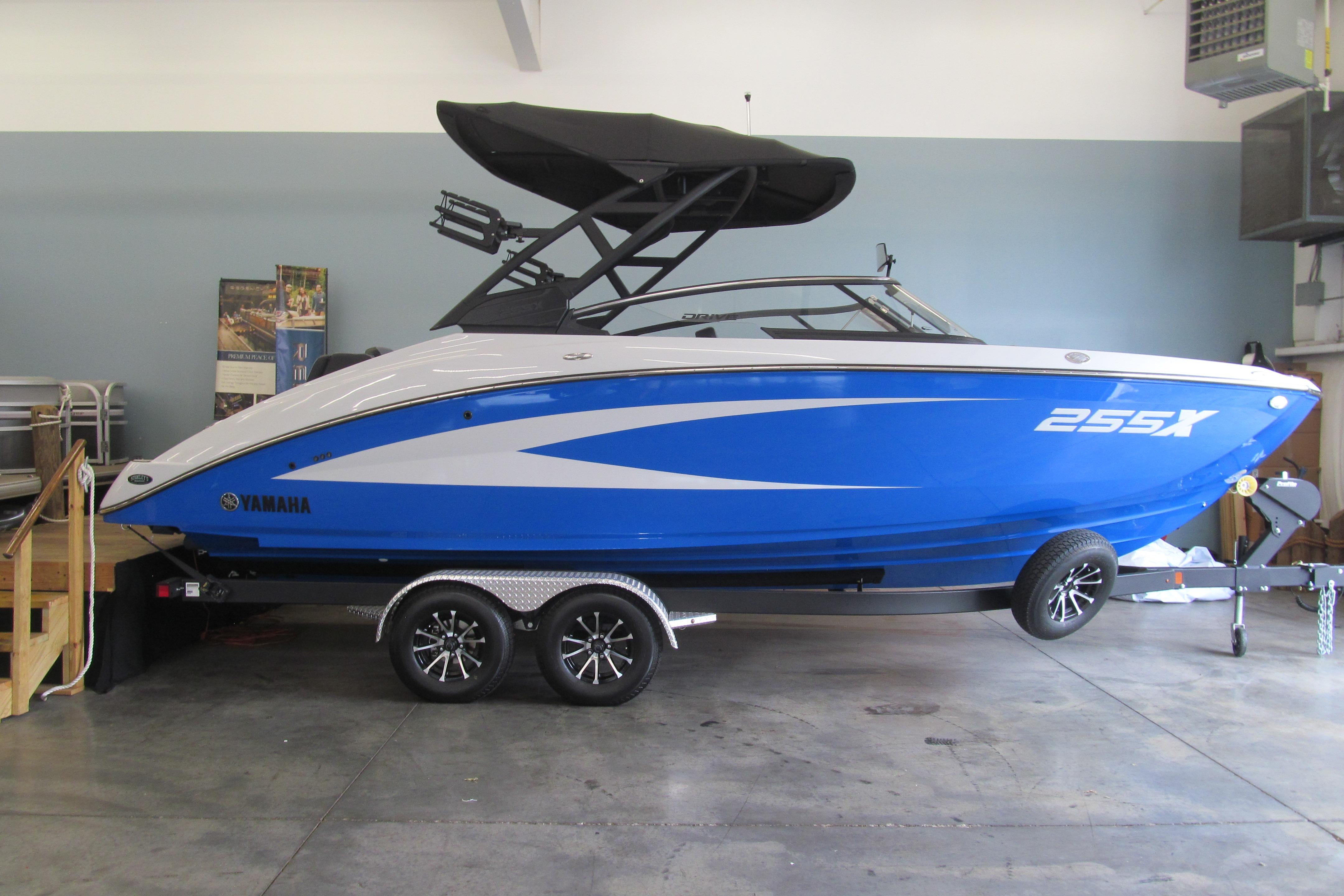 Yamaha Boats 255XD 2025 Yamaha Boats 255XD in showroom, blue and white design, on trailer.