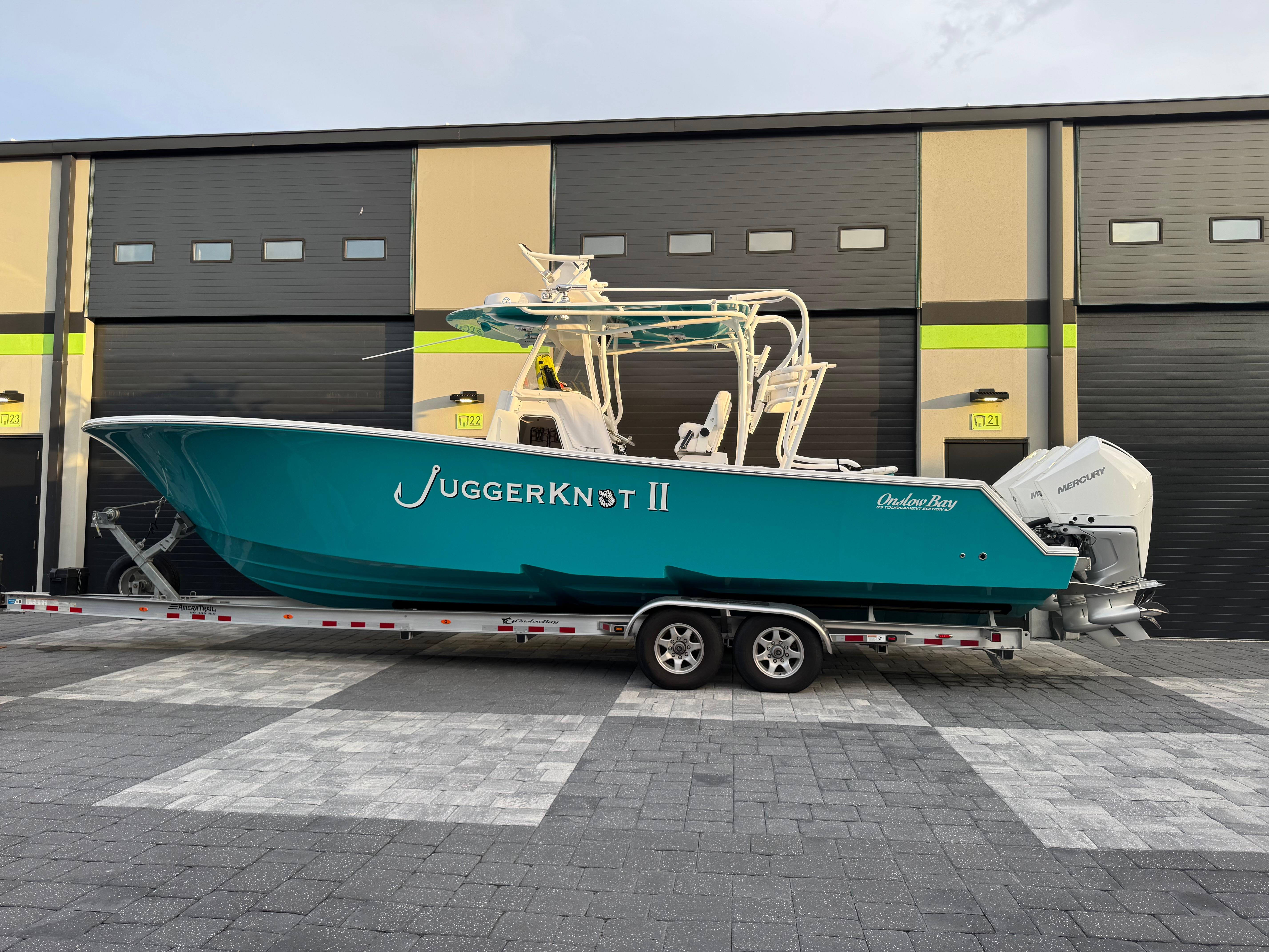 Onslow Bay 33 Tournament 2020 Onslow Bay 33 Tournament boat on trailer, parked outside a garage.