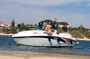 Lema Gold S 2012 Lema Gold S boat anchored near a sandy beach with houses in the background.