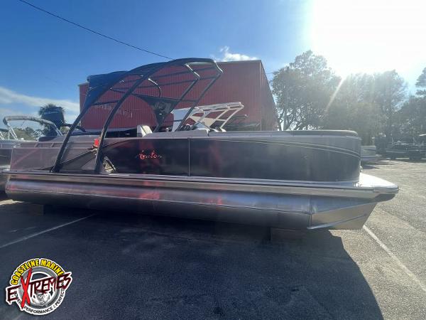 Avalon LSZ ELITE 2023 Avalon LSZ ELITE pontoon boat parked outdoors under sunlight.