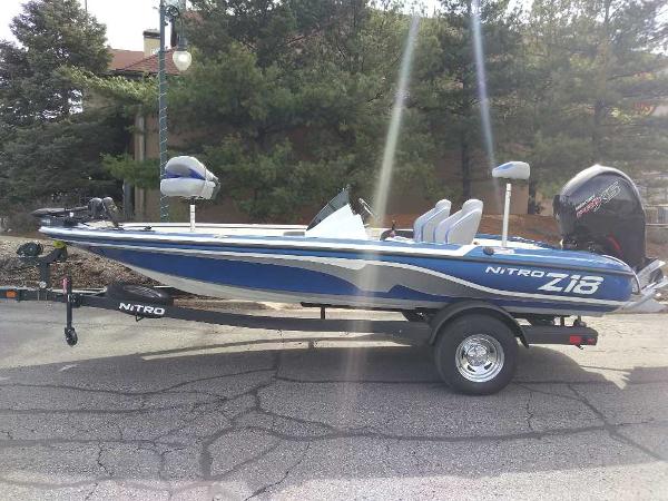 Nitro Z18 2025 Nitro Z18 boat on trailer, blue and white design, parked outdoors.