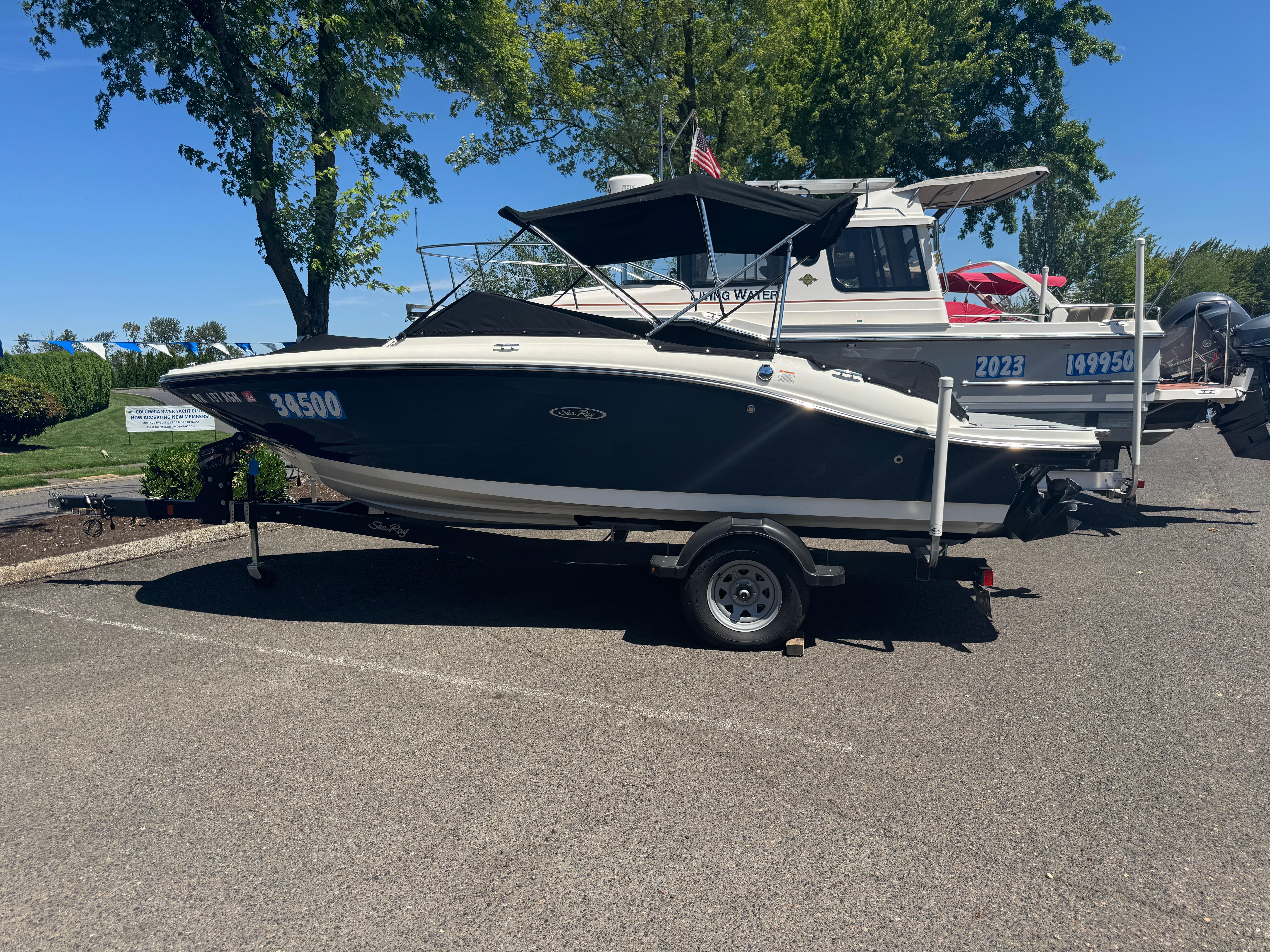 Sea Ray SPX 190 2019 Sea Ray SPX 190 boat on trailer, parked outdoors under trees.