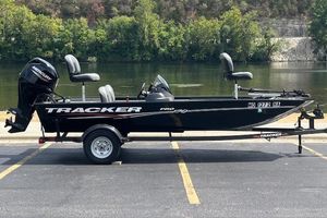 Tracker Pro 170 2024 Tracker Pro 170 boat on trailer by a river, featuring Mercury outboard motor.