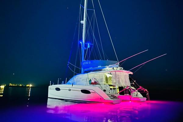Leopard 39 2012 Leopard 39 catamaran illuminated at night with vibrant underwater lights.