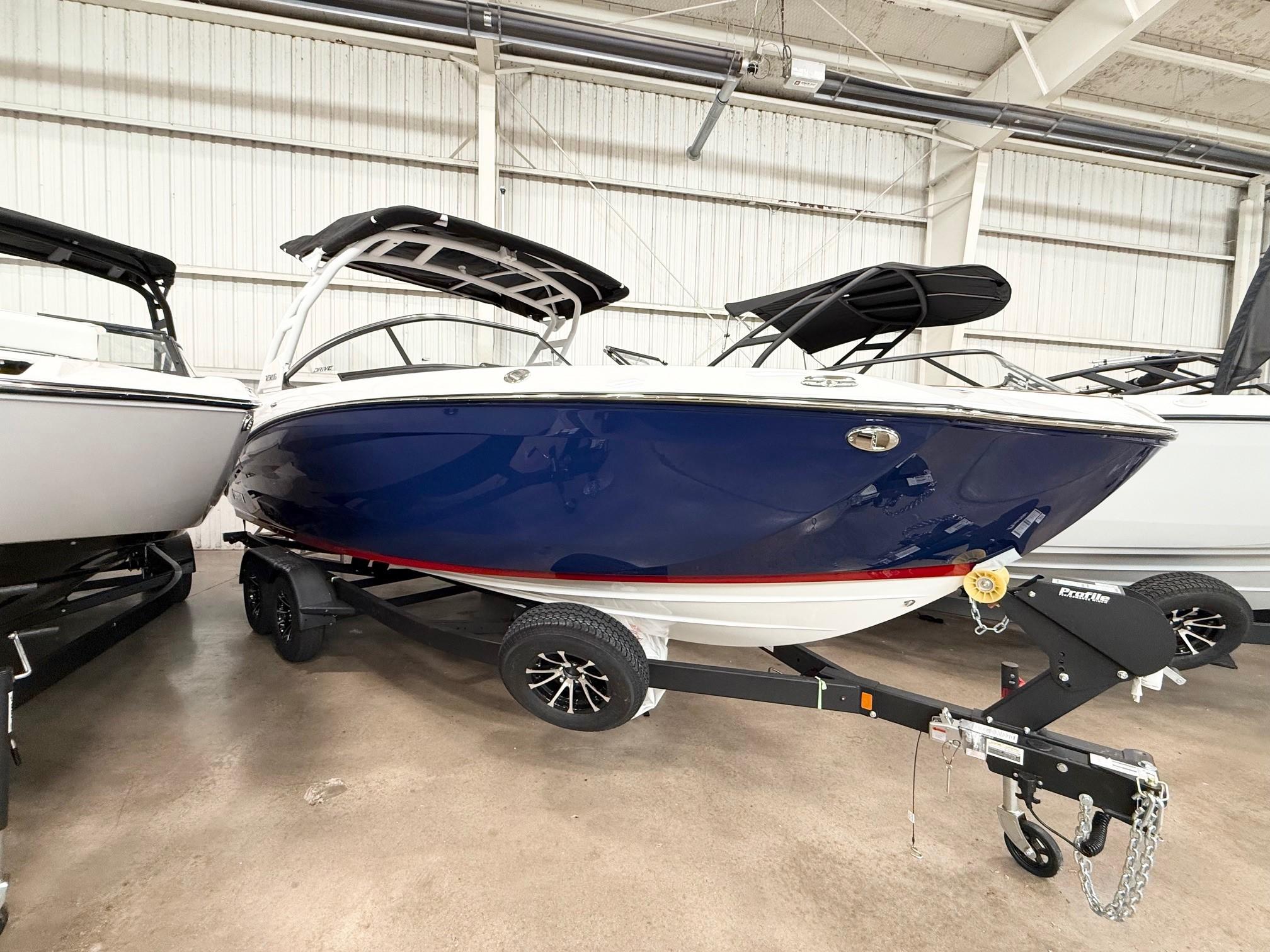 Yamaha Boats 252SD 2025 Yamaha Boats 252SD in showroom, blue hull, on trailer, indoor display.