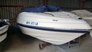 Chaparral 215 SSi 2004 Chaparral 215 SSi boat in storage, covered with a blue tarp.