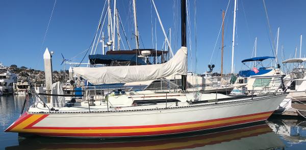 C&C 41 1986 C&C 41 sailboat docked in marina, featuring colorful hull stripes.