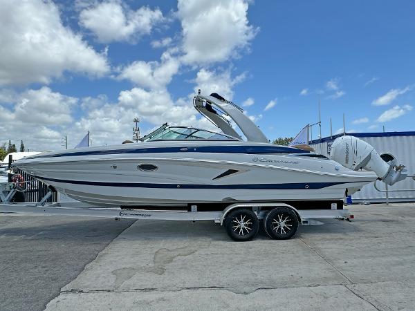 Crownline 290 XSS 2024 Crownline 290 XSS boat on trailer under blue sky.