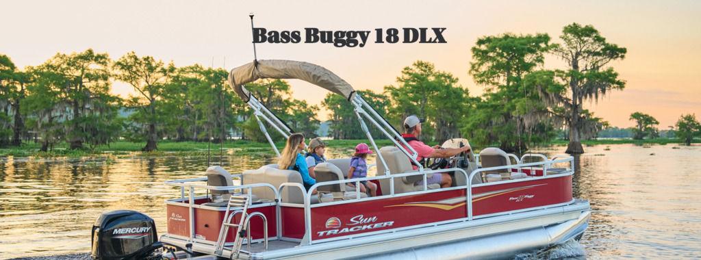 Sun Tracker Bass Buggy 18 DLX 2026 Sun Tracker BASS BUGGY® 18 DLX pontoon boat cruising on a scenic lake at sunset.