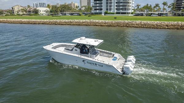 Sedna 37 Open 2025 Sedna 37 Open boat cruising on water near a coastal cityscape.
