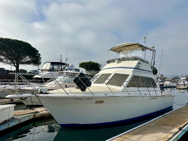 Egg Harbor 33 Sedan 1985 Egg Harbor 33 Sedan boat docked in marina, under cloudy sky.