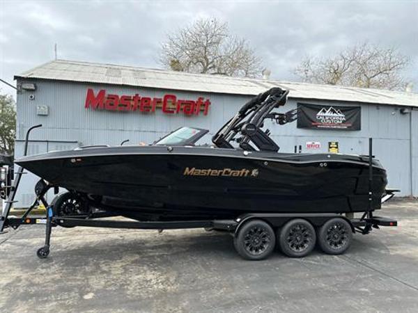 MasterCraft X24 2024 MasterCraft X24 boat on trailer outside dealership.