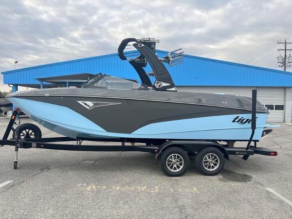 Tigé Z5 2024 Tigé Z5 boat on a trailer, parked outside a blue building.