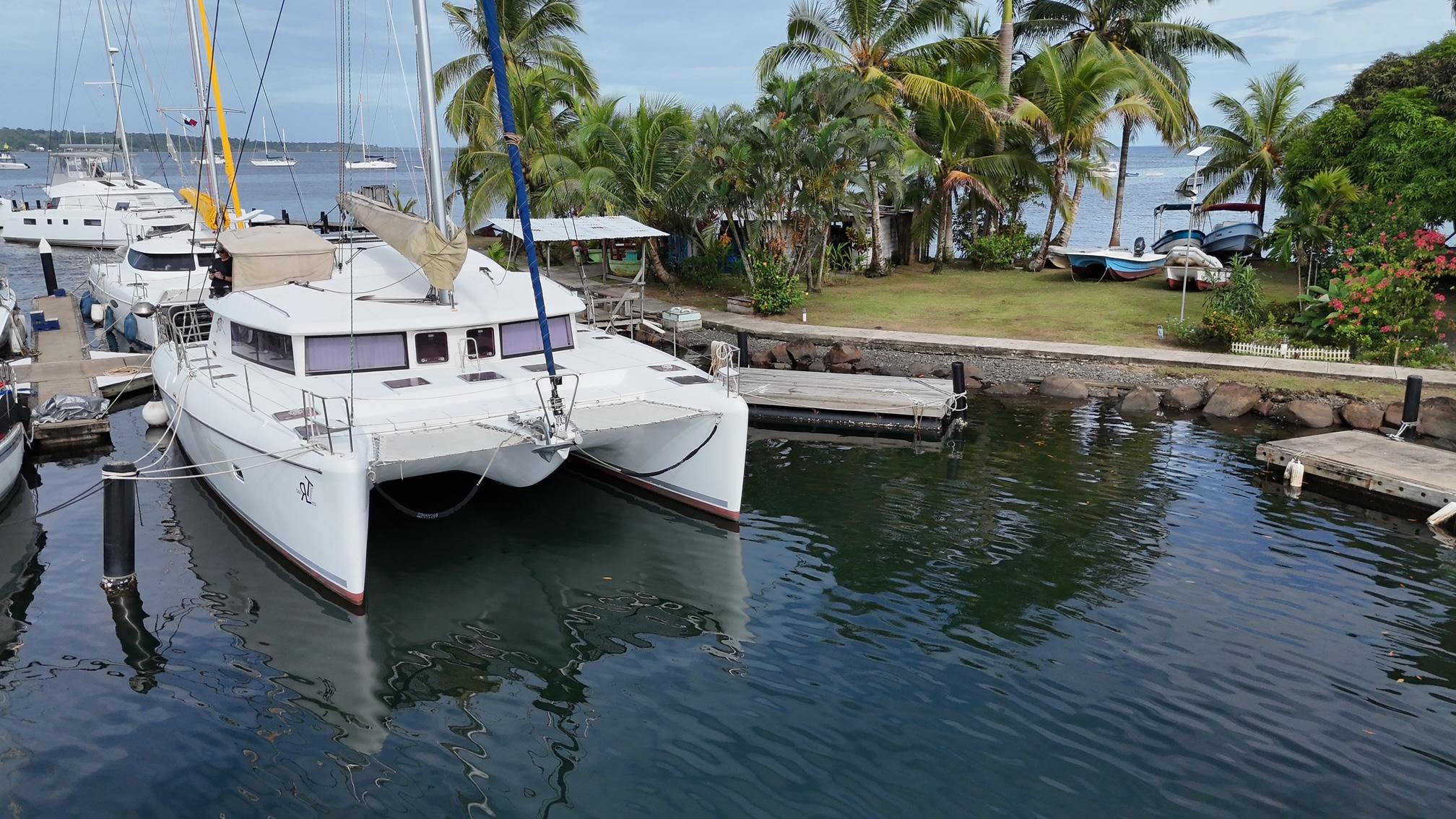 Lagoon 421 2013 Lagoon 421 catamaran docked near tropical shoreline with palm trees.