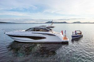Princess V50 Open 2021 Princess V50 Open yacht on calm water with small boat nearby.