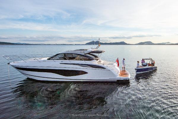Princess V50 Open 2021 Princess V50 Open yacht on calm water with small boat nearby.