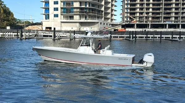 Regulator 34 2020 Regulator 34 boat cruising near urban waterfront construction site.