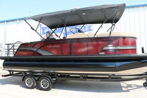 Sylvan L3 CLZ DH 2025 Sylvan L3 CLZ DH pontoon boat with red and black design on trailer.