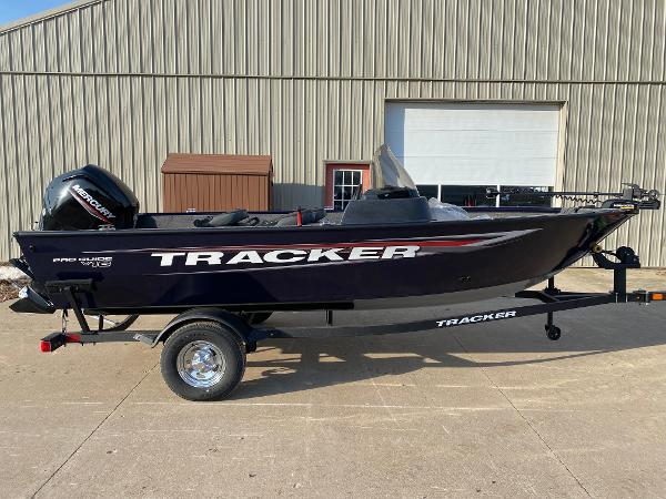 Tracker Pro Guide V-16 SC 2025 Tracker Pro Guide V-16 SC boat on trailer, parked outside a warehouse.