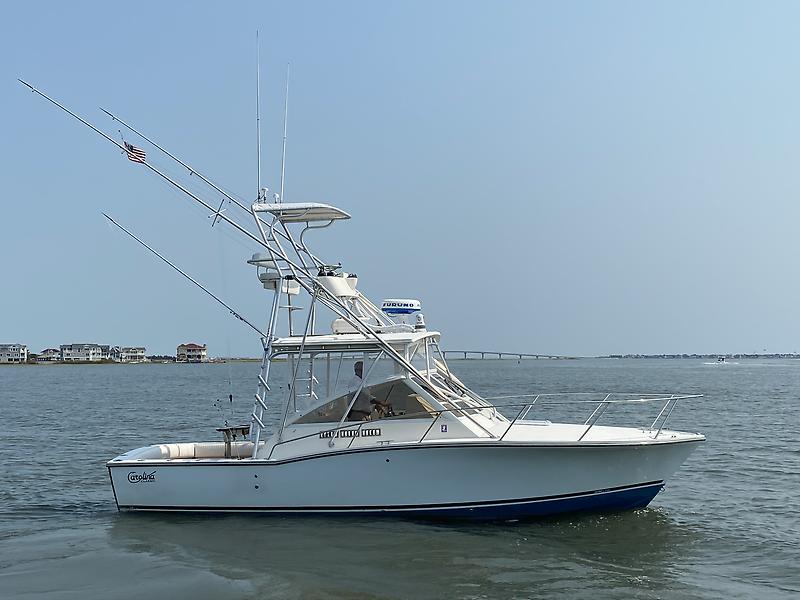 Carolina Classic 28 Express 2006 Carolina Classic 28 Express boat on calm water, with clear sky background.