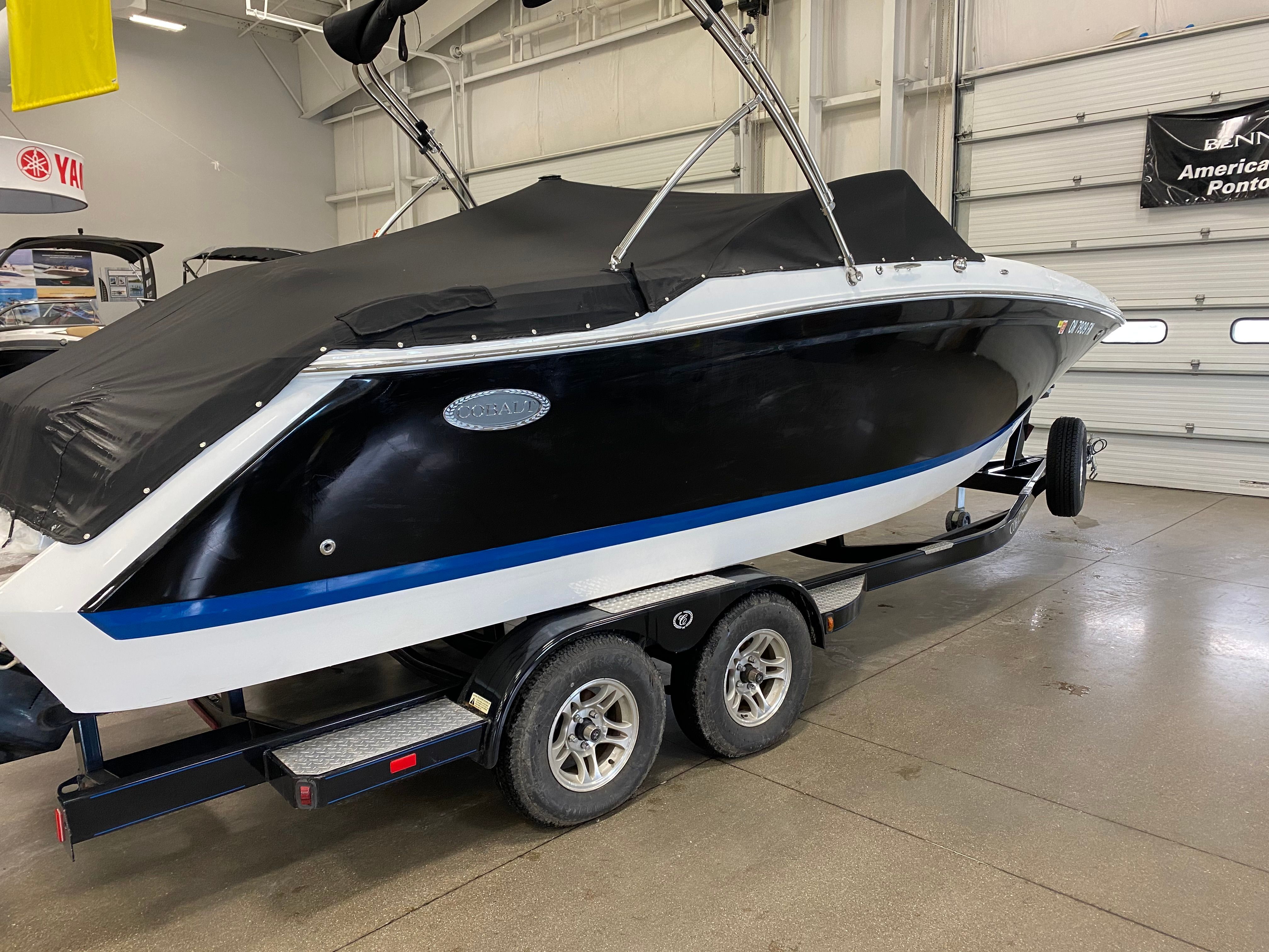 Cobalt Sport Deck 2014 Cobalt Sport Deck boat with black cover on trailer in indoor showroom.