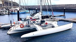 Custom TRIMARAN POLYNESIA 45 Custom TRIMARAN POLYNESIA 45, 2002 model, docked in a marina with clear blue water.