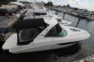 Sea Ray Sundancer 310 2015 Sea Ray Sundancer 310 docked at a marina, featuring sleek design and black canopy.