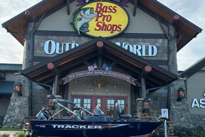 Tracker Pro Guide V-16 SC 2026 Tracker Pro Guide V-16 SC boat outside Bass Pro Shops store.
