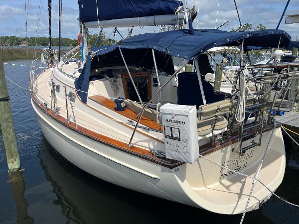 Island Packet 350 1997 Island Packet 350 sailboat docked, featuring blue canvas covers and wooden accents.