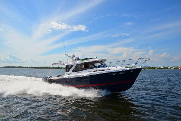 Cutwater C-302 Coupe 2019 Cutwater C-302 Coupe cruising on open water under a clear blue sky.