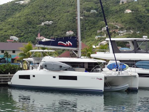 Leopard 45 2020 Leopard 45 catamaran docked in a scenic marina with lush green hills.