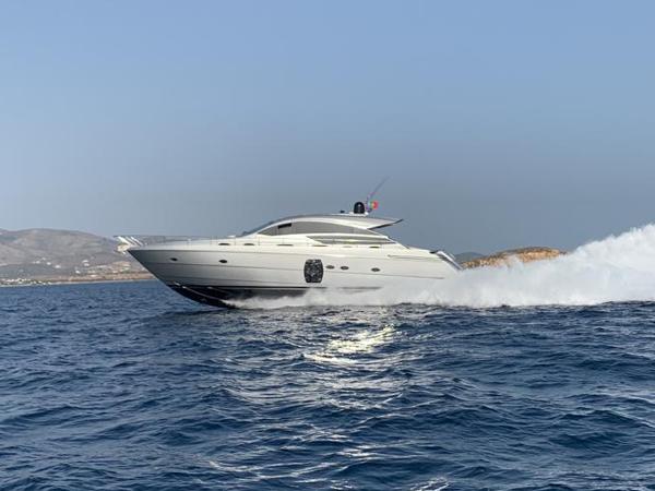 Pershing 64 2009 Pershing 64 yacht cruising on open sea with mountainous coastline in background.