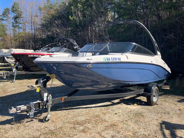 Yamaha Boats 195S 2024 Yamaha Boats 195S on trailer, parked outdoors, surrounded by trees.
