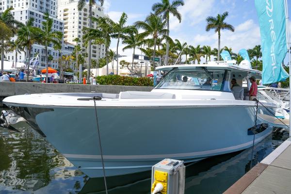 Regal 50 SAV 2026 Regal 50 SAV boat docked at marina with palm trees and buildings in background.