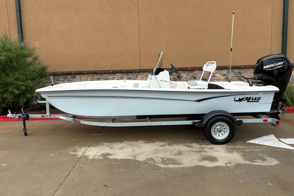 Mako Pro Skiff 17 CC 2026 Mako Pro Skiff 17 CC boat on trailer, side view, outdoors.